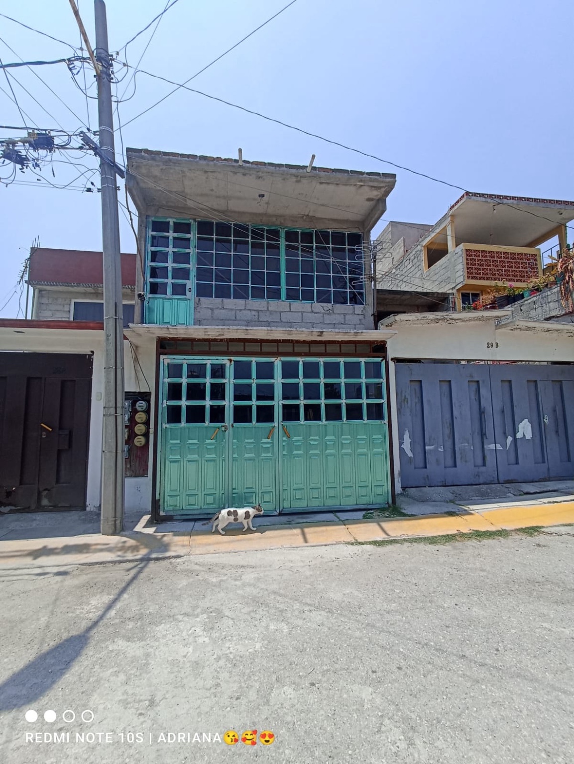 Fachada de inmueble con portón verde
